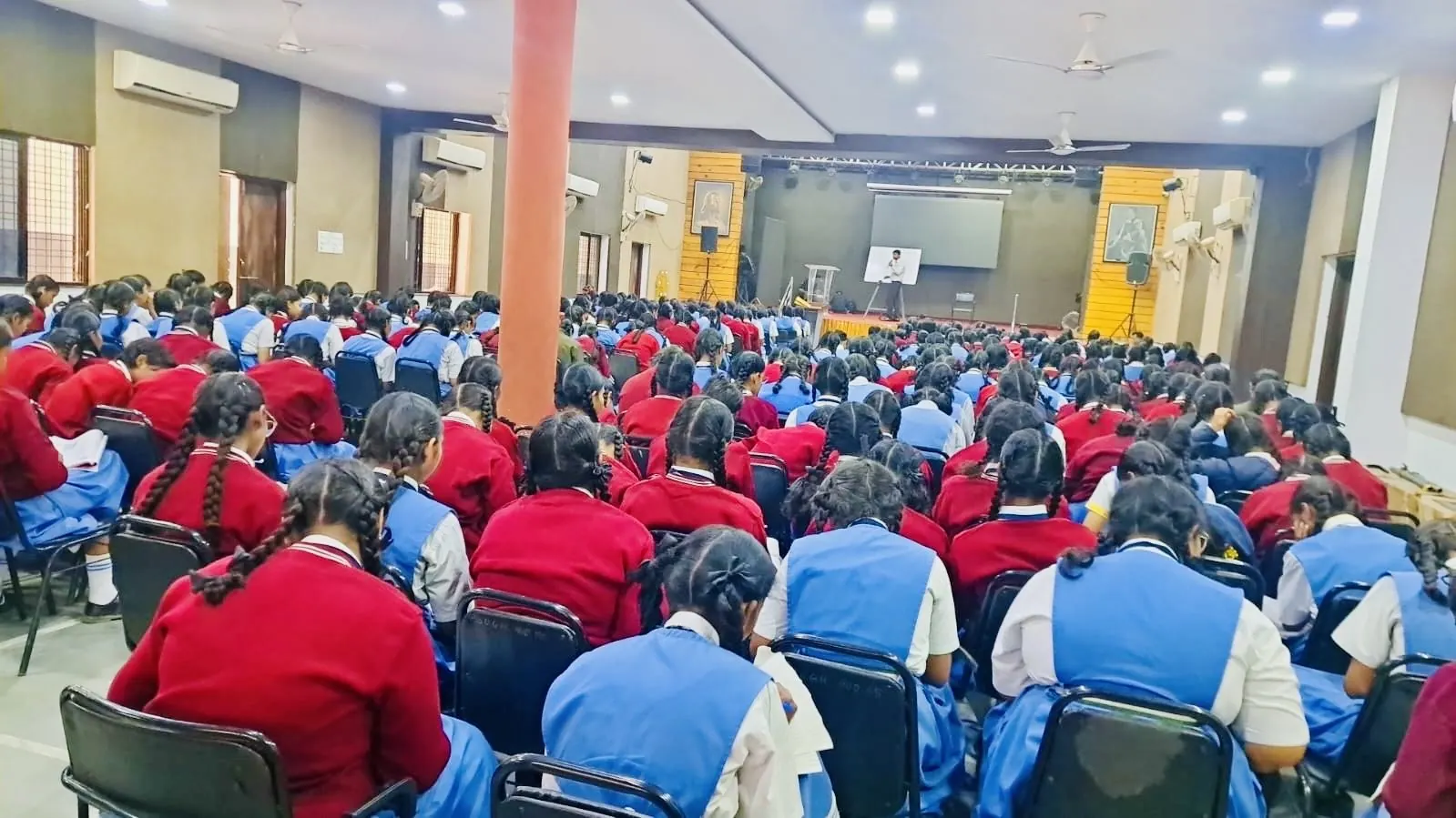 Students in uniform attending an evening lecture