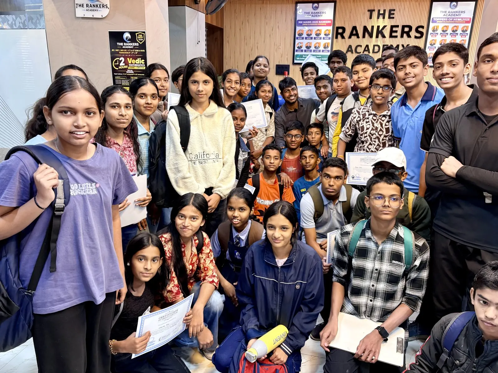 Founders and student posing indoors near backdrop