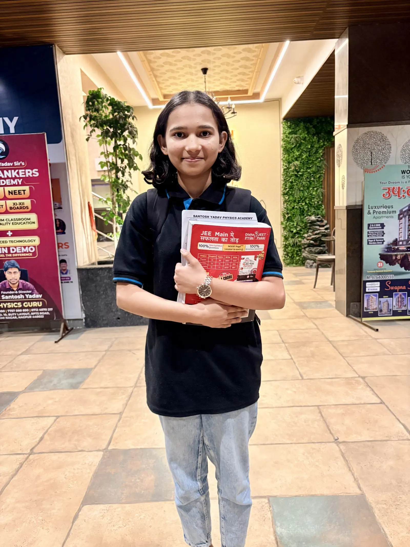 Confident student holding textbook near school signage