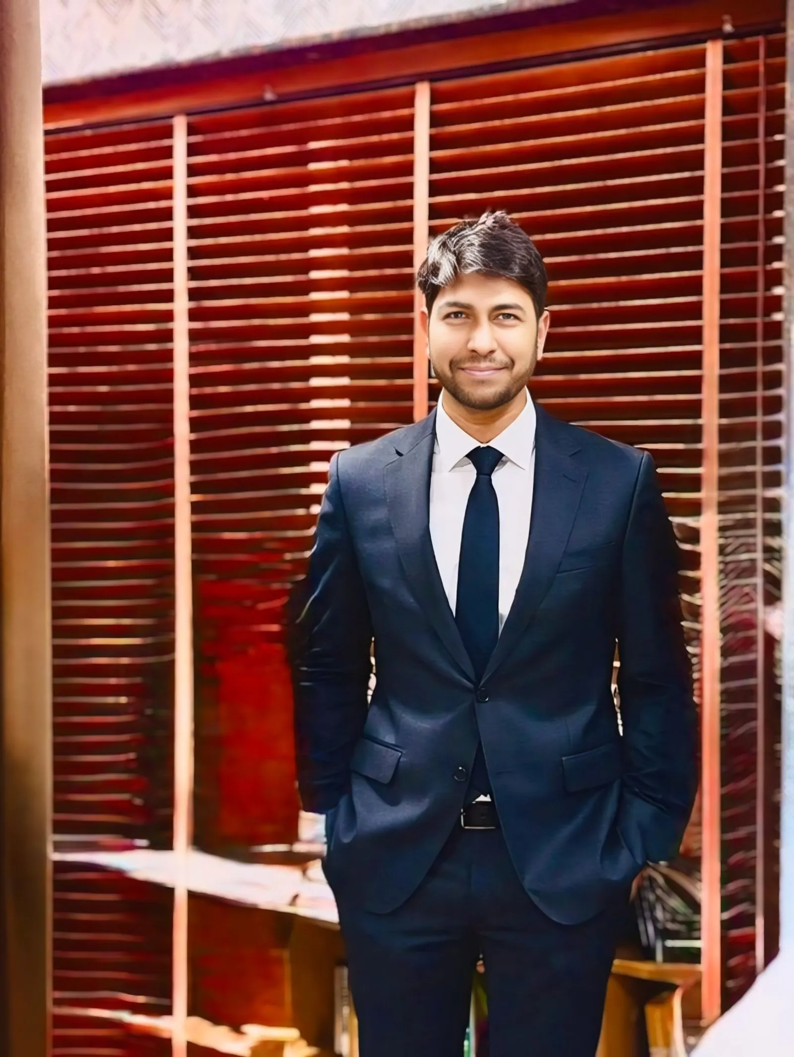 Founder in formal attire near office window
