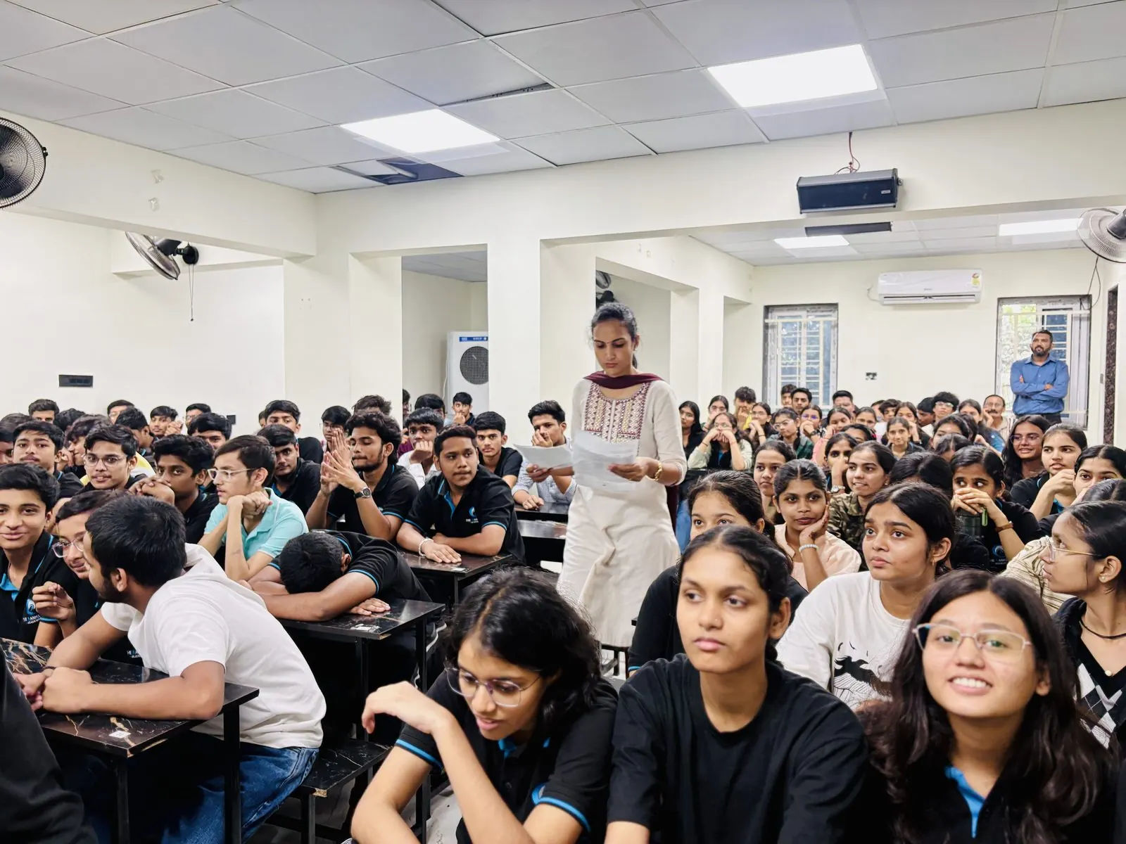 Founder addressing students in a full classroom